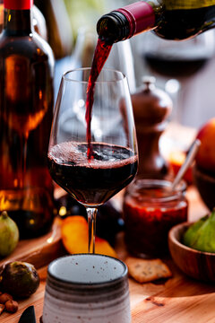 Delicious Merlot red wine in crystal glassware for restaurant lunch, mindful eating concept. Alcoholic beverage served with charcuterie plate. Modern culinary arts and tasting event.