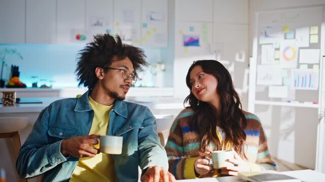Coworkers chatting coffee break home office. Multiethnic partners holding mugs.