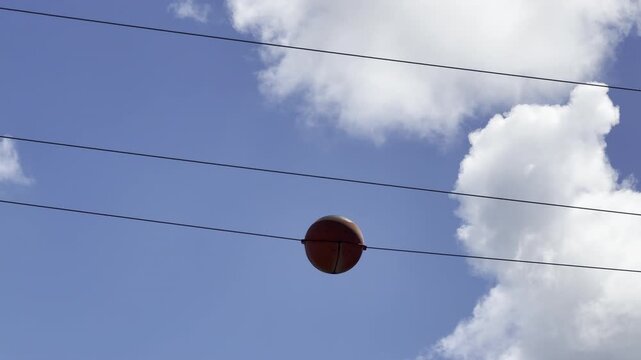 The orange balls on power lines are aviation safety markers designed to make thin power cables visible to low-flying pilots.  City of Honolulu, Oahu island, Hawaii
