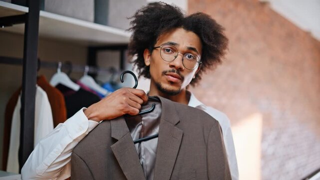 Customer comparing suit jackets hangers. Closeup shopper choosing blazer store.