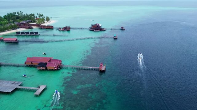 Derawan Island, Berau, Indonesia - Aerial drone view of overwater bungalow resort with turquoise clear water and speedboats at Pulau Derawan on January 3, 2026