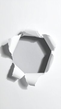 A hexagonal hole ripped in white paper, casting a soft shadow