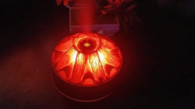 Top view of volcano mist diffuser crater glowing red with steam rising