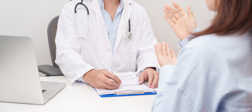 Doctor and patient having a medical consultation with white ribbon for November Lung Cancer Awareness month, explaining a treatment plan, discussing diagnosis, and giving professional advice