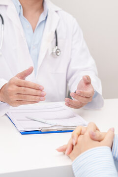 Doctor and patient having a medical consultation with white ribbon for November Lung Cancer Awareness month, explaining a treatment plan, discussing diagnosis, and giving professional advice