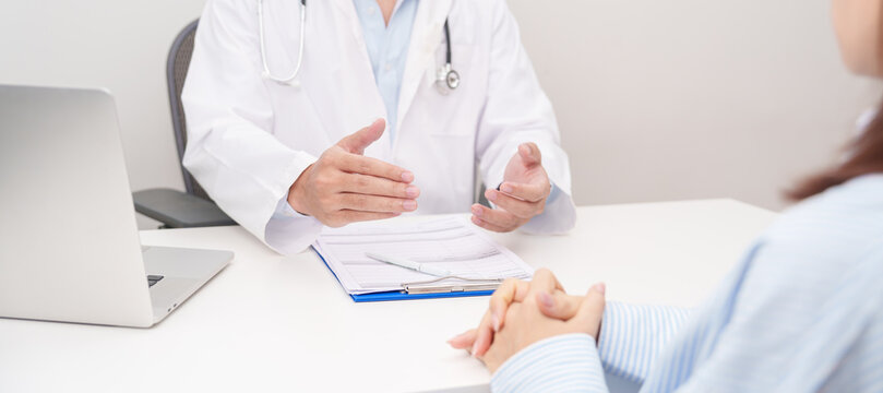 Doctor and patient having a medical consultation with white ribbon for November Lung Cancer Awareness month, explaining a treatment plan, discussing diagnosis, and giving professional advice