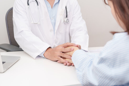 professional doctor holding patient hand to comfort and support with empathy for November Lung Cancer Awareness month, World Cancer Day and health consultation concept in hospital