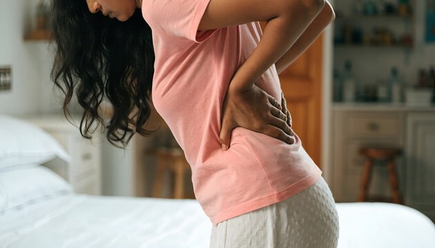 Adult Woman Experiencing Lower Back Pain at Home, Representing Backache, Muscle Strain, and Health Discomfort