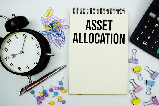 Asset Allocation text written on notepad with calculator and alarm clock