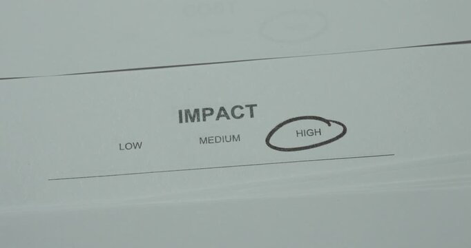Close-up of high impact level circled on an assessment document. Concept for risk evaluation, priority, decision making and business analysis.
