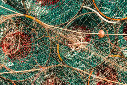 Italy, Sardinia, Bosa. Brightly coloured fishing nets piled up on the dock in the harbour