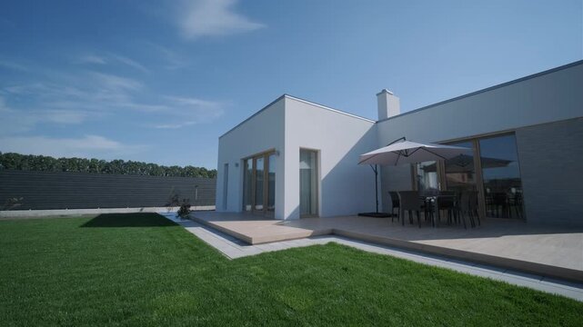Modern single-story house with a flat roof and white facade.   