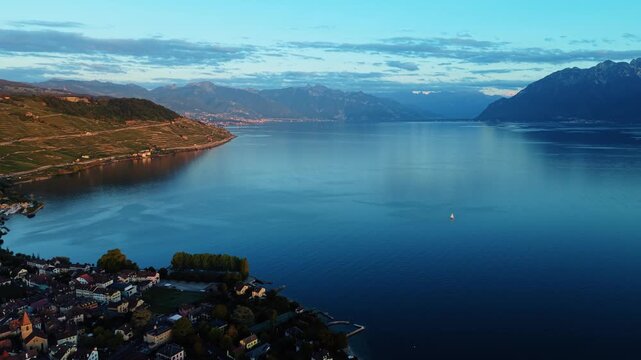 Drone pulls back from Lake Geneva toward the town of Cully, Switzerland