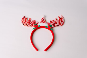 Red sequin reindeer headband with mini santa hat isolated on white background, ideal for christmas party, holiday costume, and winter celebration.  © Ryan