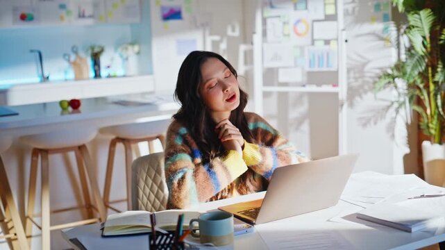 Asian freelancer video call laptop home office. Woman gesturing explaining work.