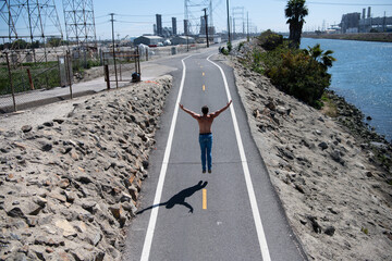 Obraz premium Freedom and happiness concept. Man jumping on road. Success and energy. Motivation lifestyle. Man freedom outdoors. Motivation and balance. Man with open arms jump outdoors. Victory and success.