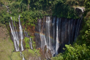 Tumpak Sewu Waterfall with Rainbow and Multiple Cascades in Tropical Forest © Paul