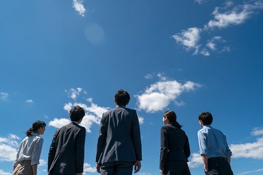 希望に満ちた青空を見上げ未来へ歩むビジネスチーム新しい挑戦