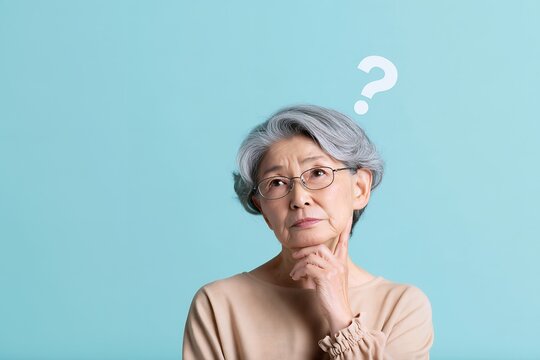 疑問を抱き顎に手を当て考え込むシニア女性の悩む姿