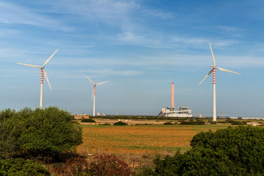 Italy, Sardinia, Porto Torres.  The Fiume Santo coal burning power station, alongside newer wind turbines