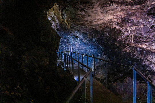 Illuminated interior of Prometheus Cave near Kutaisi, Georgia, with stalactites and dramatic geological formations along a tourist route.
