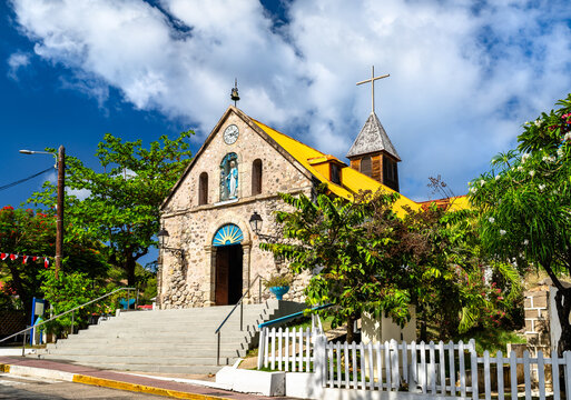 Stone facade and yellow roof of the historic Catholic church in Terre-de-Haut, Les Saintes, Guadeloupe.