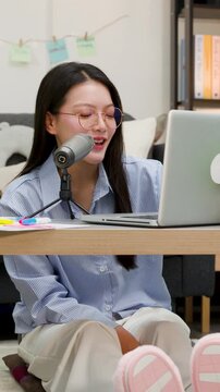 Asian Woman Podcasting and Video Conferencing with Laptop at Home