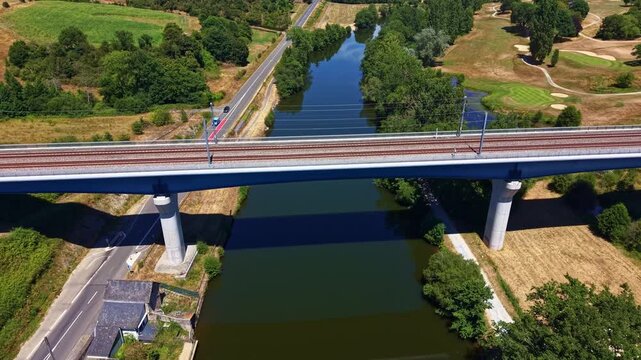 A81 L'Armoricaine highway bridge with traffic crossing the Mayenne River surrounded by green trees in Chang&eacute;, France. Aerial backward