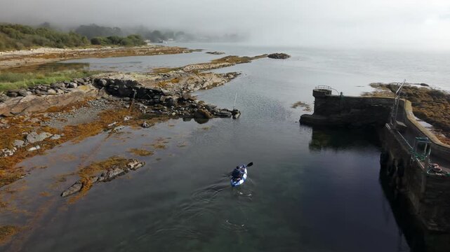 Aerial drone footage of a person canoeing on the coastal waters near Ahakista in West Cork, Ireland. The shot captures a lone paddler exploring the scenic Irish coastline.
