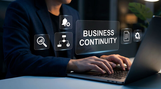 Professional man working on laptop with business continuity technology hologram