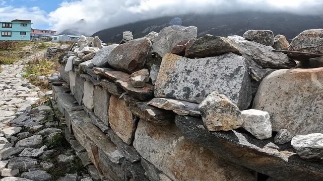The Mani walls on the way to old Langtang village in Langtang valley, Nepal. This rock created as a form of devotional practice, piety, and virtue in Tibetan Buddhism to accumulate spiritual merit.