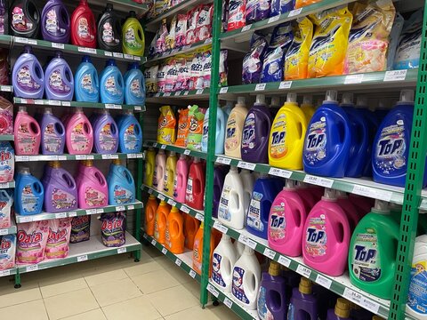 Negeri Sembilan, Malaysia - June 26, 2025: Supermarket shelves fully stocked with various laundry detergent and fabric softener bottles in a retail store.
