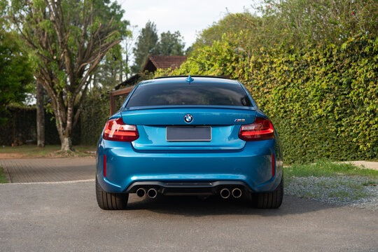 Blue BMW M2 Sports Coupe Rear View Parked On Outdoor Residential Driveway