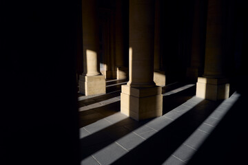 Obraz premium Dramatic light casts long shadows from building columns