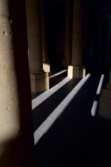 Obraz premium Sunlight creates dramatic shadows in a stone corridor