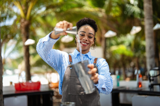 Professional bartender crafting a refreshing cocktail with expert mixing skills at a tropical bar
