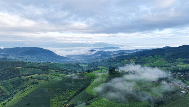 Aerial landscape view of rice terrace and wooden huts in mountains on cloudy morning