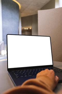 Vertical mockup image of a woman working on laptop computer with blank white desktop screen