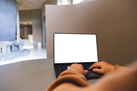 Mockup image of a woman working and typing on laptop computer with blank white desktop screen