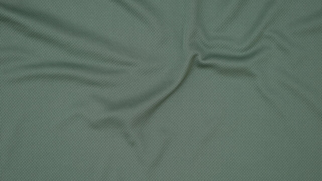 Texture of sage green jersey clothing fabric. Flatlay style, close up, studio shot. Sport background. Fabric commonly used for sportswear as football, basketball, volleyball, hockey, rugby etc