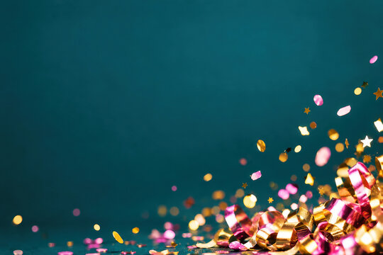 Festive new year celebration background with golden ribbons and colorful confetti on dark teal