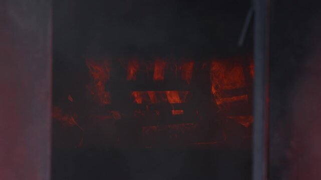 Close-up view of roaring flames and thick smoke filling a metal container during a realistic firefighting training scenario, highlighting heat, danger, and dramatic lighting effects.