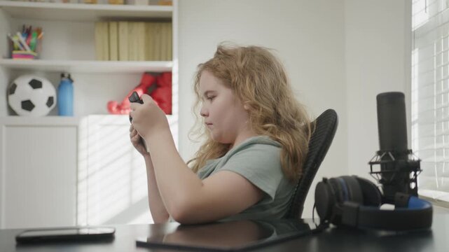Child playing video game with joystick. Child using game controller playing video console game. Teenager using game controller at home. Kid playing online computer games. Video gaming.