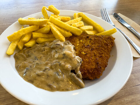 Schnitzel with Fries and Mushroom Hunters Sauce on a Plate
