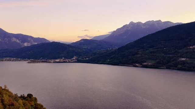 Lake Caldonazzo at twilight beneath rugged Alpine mountains