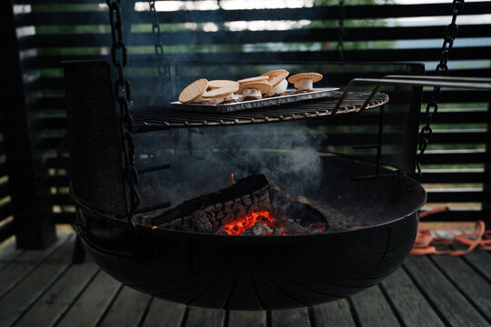 S'mores toasting on a grill over a smoky fire pit