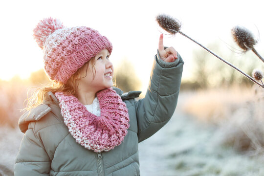 Young girl discovers frosty nature on a cold morning