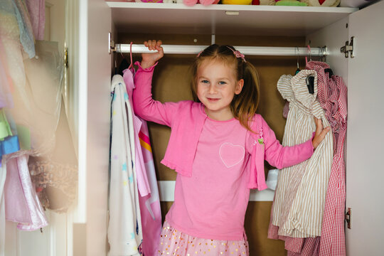 Little girl choosing her outfit from the closet