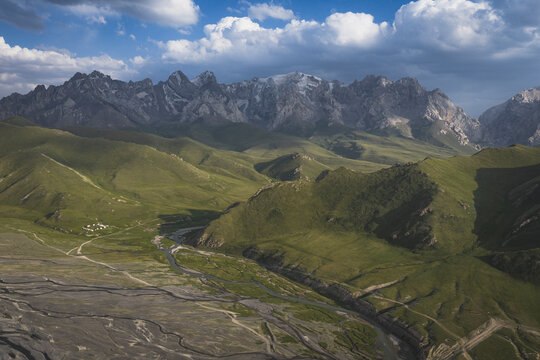 Expansive aerial view of a green valley and rugged mountain range