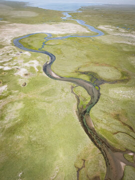 Aerial view of a winding river through a coastal marsh